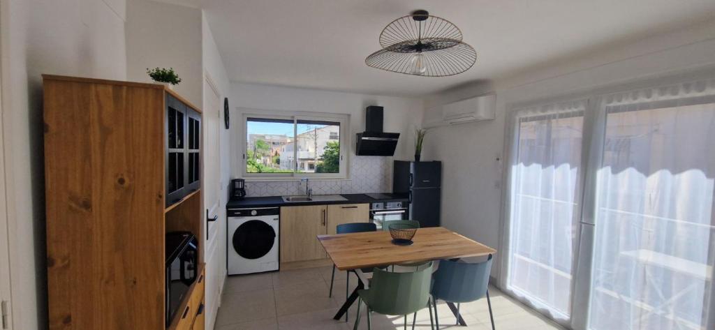 une cuisine avec une table et des chaises dans une pièce dans l'établissement Résidence Vera Cruz à 50m de la plage, à Canet