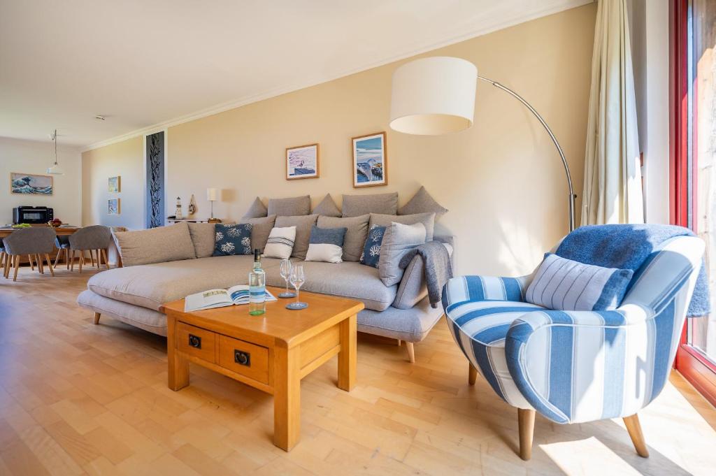 een woonkamer met een bank, twee stoelen en een tafel bij Eagle mit Ostseeblick - Haus Fore zu Schloss Ranzow in Lohme