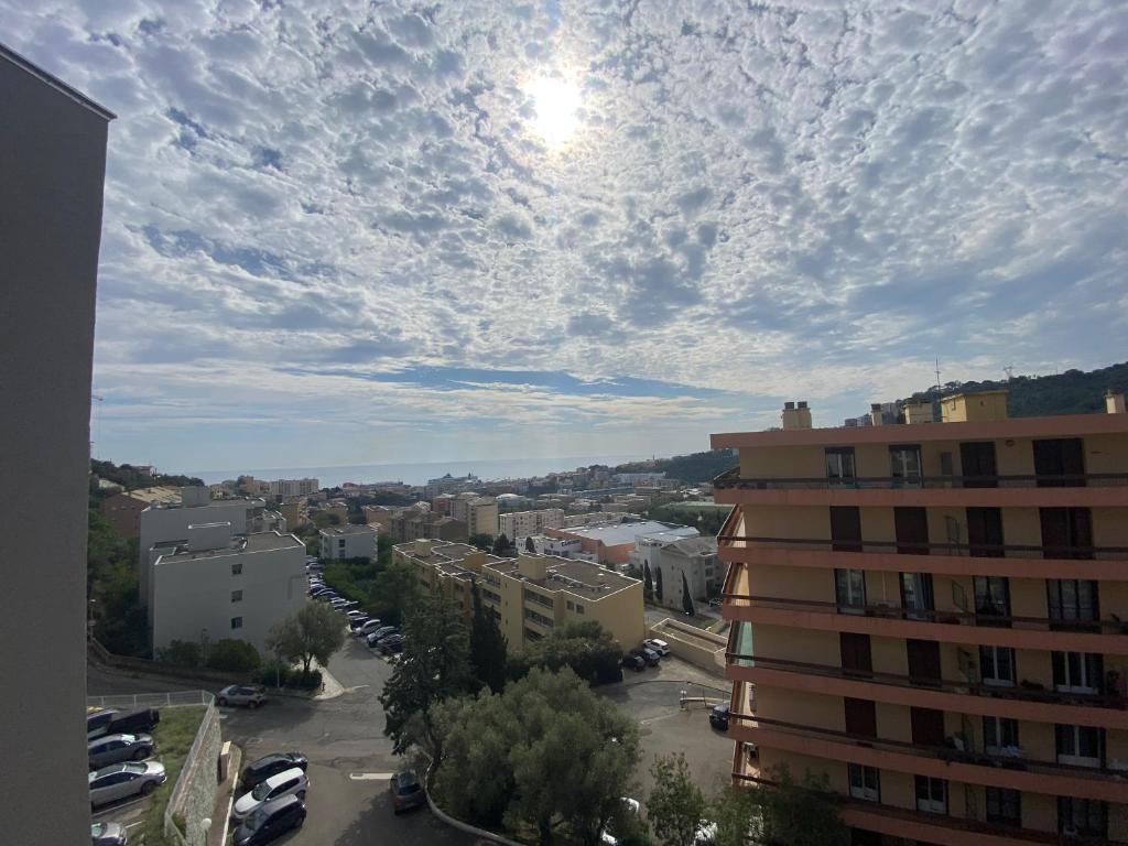 une vue d'une ville avec des voitures garées dans un parking dans l'établissement Apparemment Bastia, à Bastia