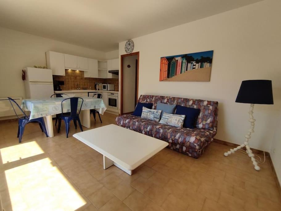 un salon avec un canapé et une table dans l'établissement Maisonnette à Chaucre en résidence avec piscine collective, à Saint-Georges-dʼOléron