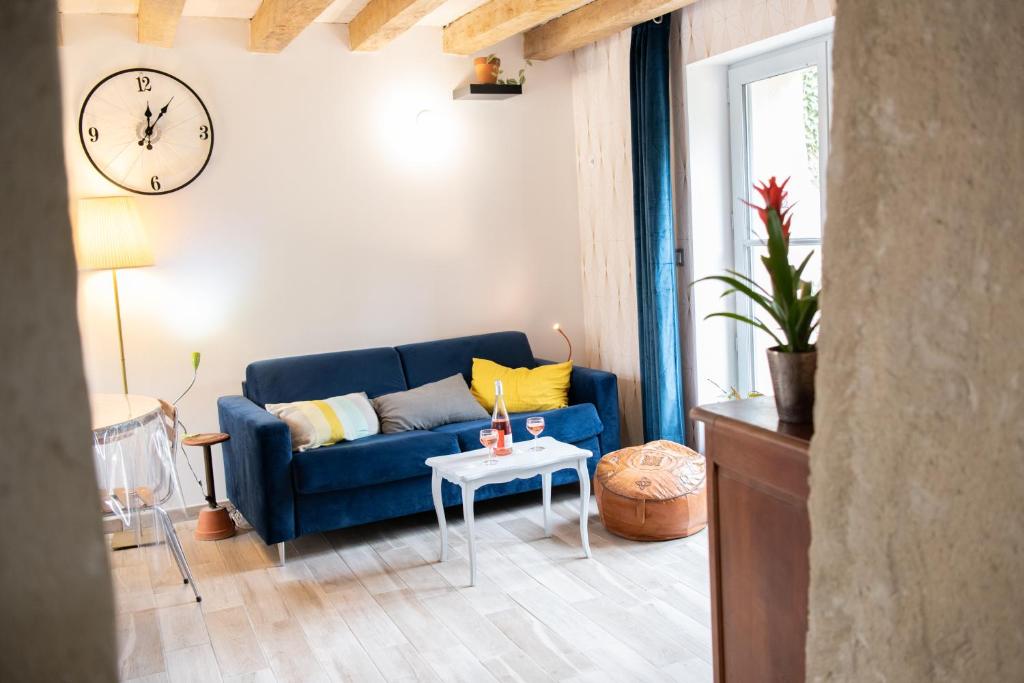 un salon avec un canapé bleu et un réveil dans l'établissement Les gîtes des Châteaux - Les Brûleries, à Vallières-les-Grandes