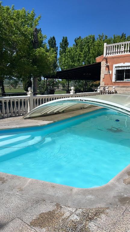 a large swimming pool with blue water in a yard at Casa Rural La Casona de Oreja in Aranjuez