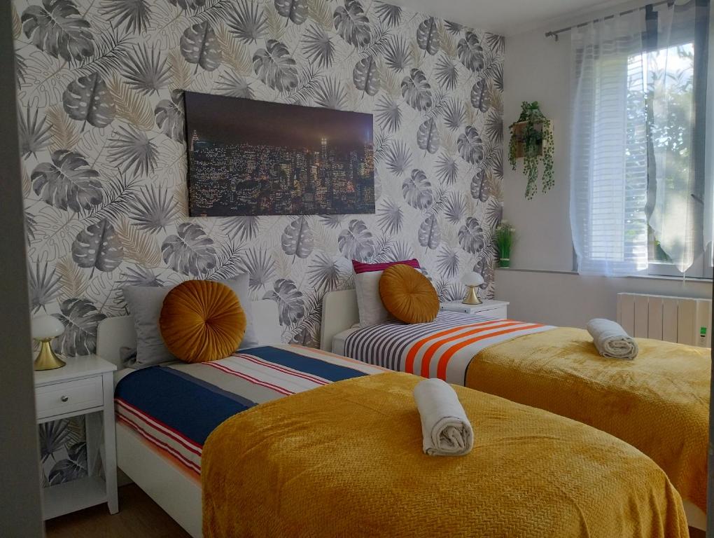 - une chambre avec 2 lits et une télévision murale dans l'établissement Appartement le Trésor d'amour, à Noyers-sur-Cher