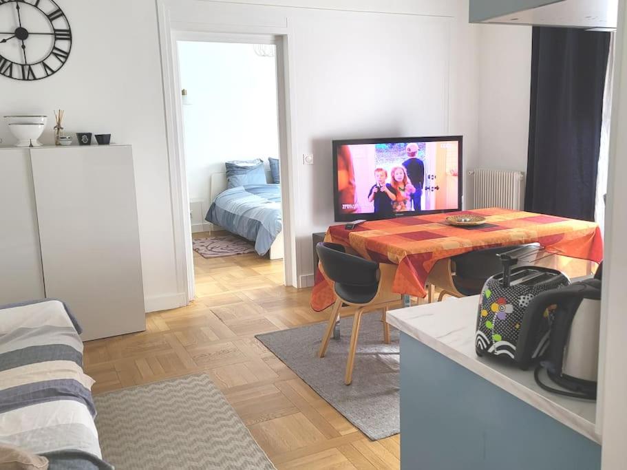 un salon avec une table et une télévision dans l'établissement Paris/La Défense 10' en train 2 CHB, à Colombes