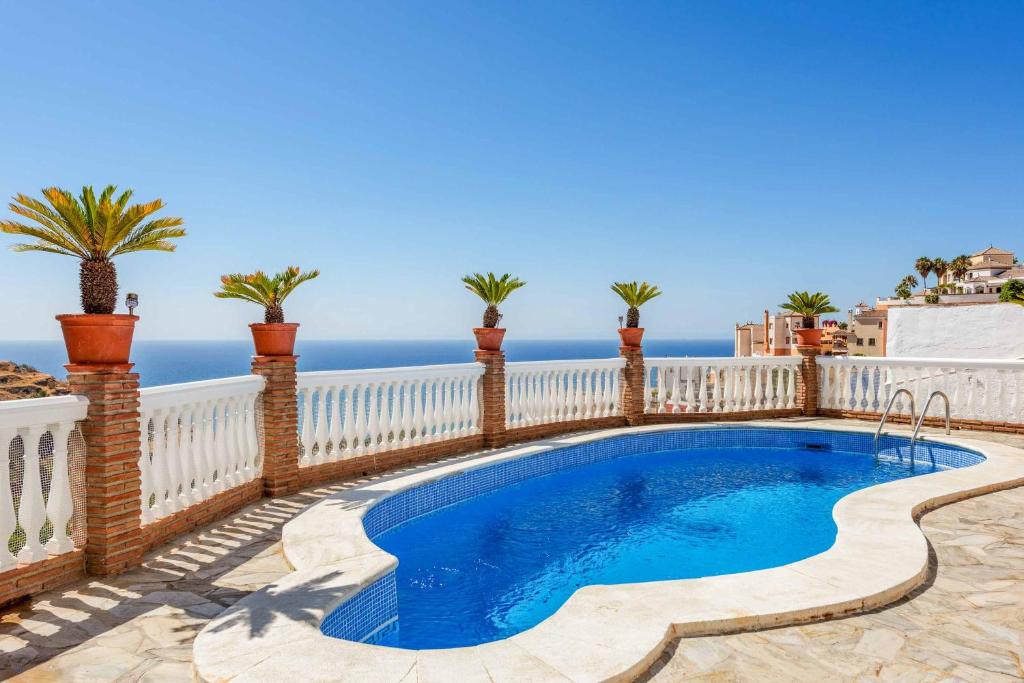 een zwembad op een hek met de oceaan op de achtergrond bij Villa Cecilia Sol in Torrox