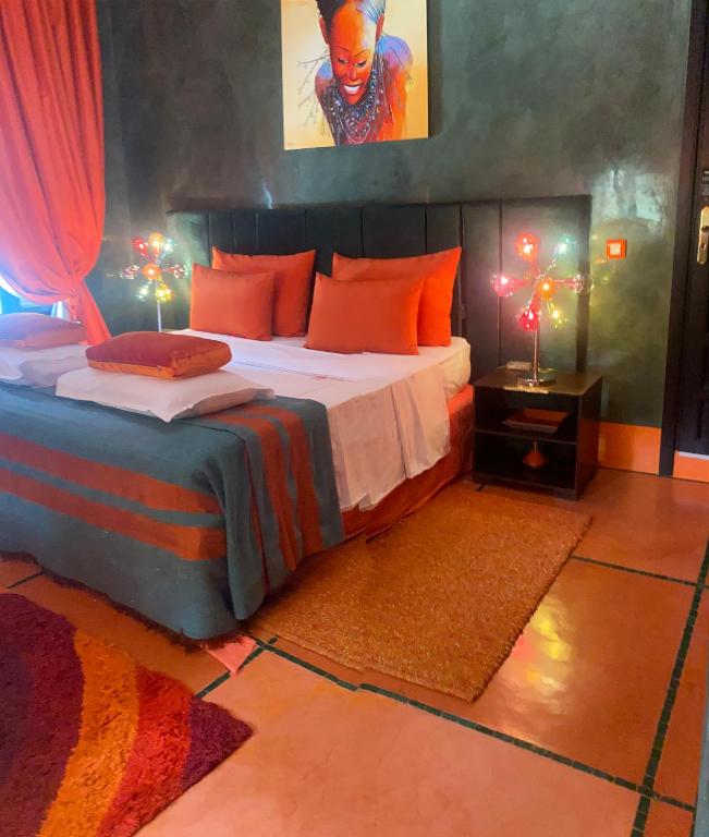 um quarto com uma cama grande e almofadas laranja em Villa Mano em Marraquexe