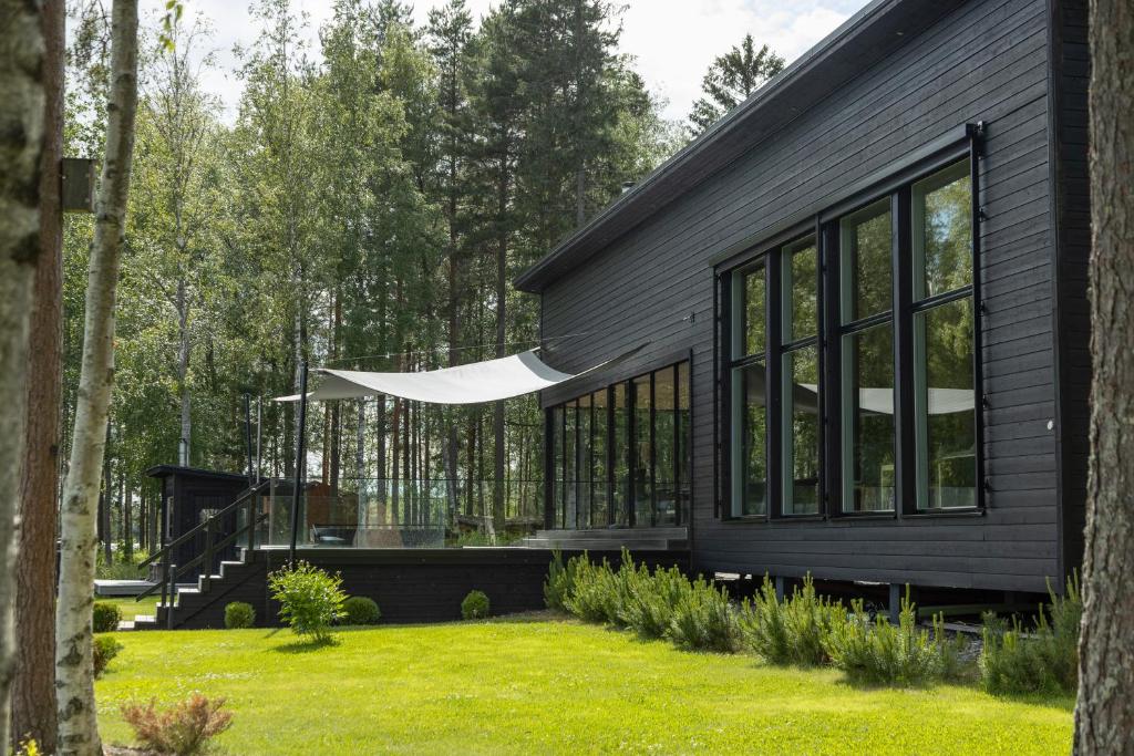 a black house with windows and a lawn at Villa Bläk in Alavus