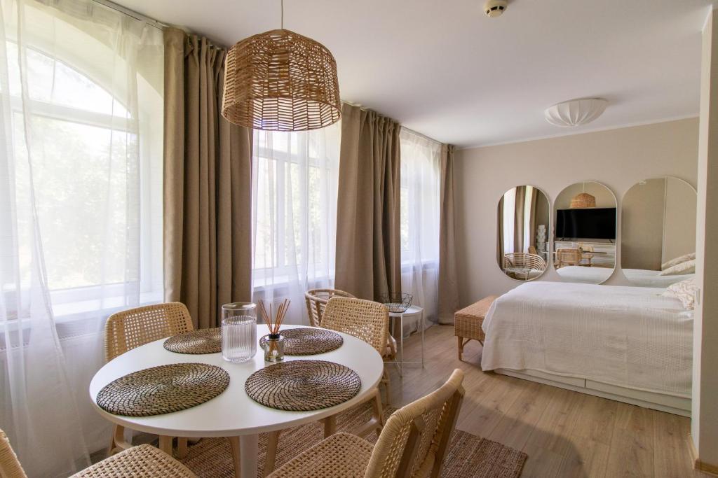 a room with a bed and a table and chairs at Harmony Hill Apartments in Druskininkai