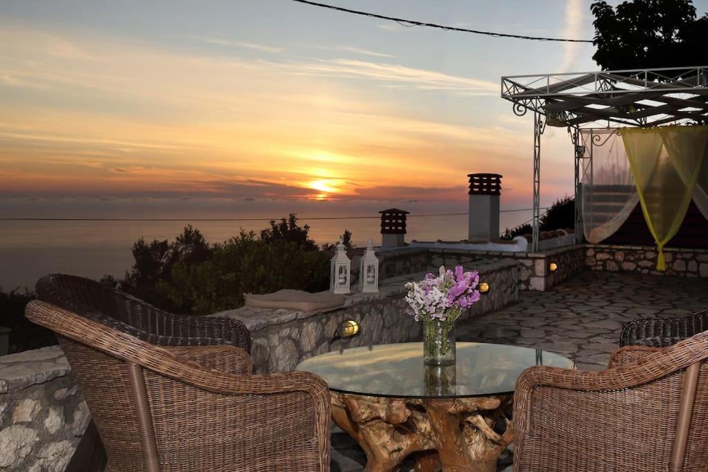 a patio with a table and chairs and a sunset at dreamOn in Lefkada