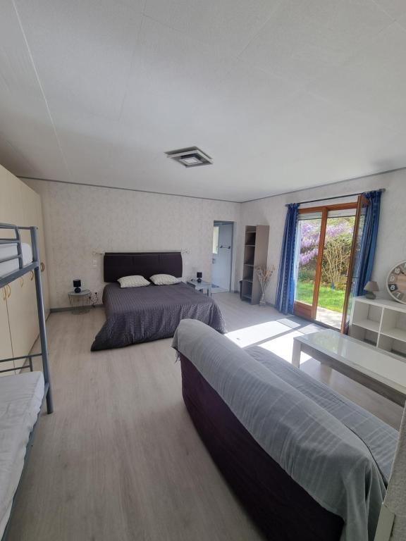 - une grande chambre avec 2 lits et une table dans l'établissement chambres d'hôtes Le Boisseau, à Saint-Michel-de-Montaigne