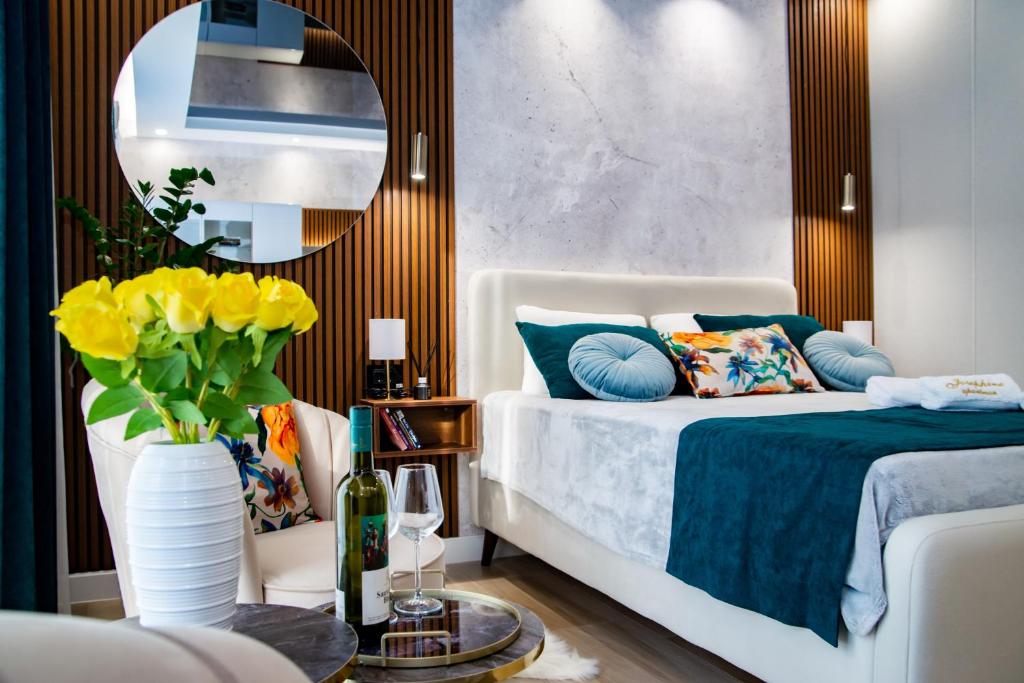 a bedroom with a bed and a vase with yellow flowers at Josephine Apartment in Subotica