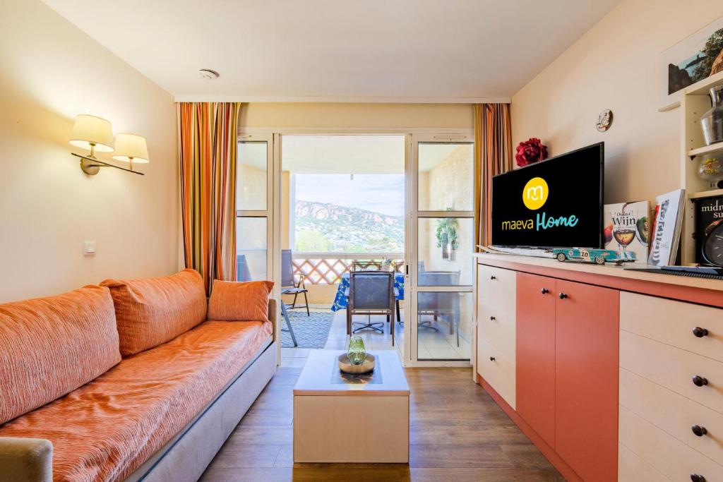 un salon avec un canapé et une télévision dans l'établissement Résidence le Village de Cap Esterel - maeva Home - Appartement 2 pièces 4 personnes - Sélection MAE-3781, à Saint-Raphaël