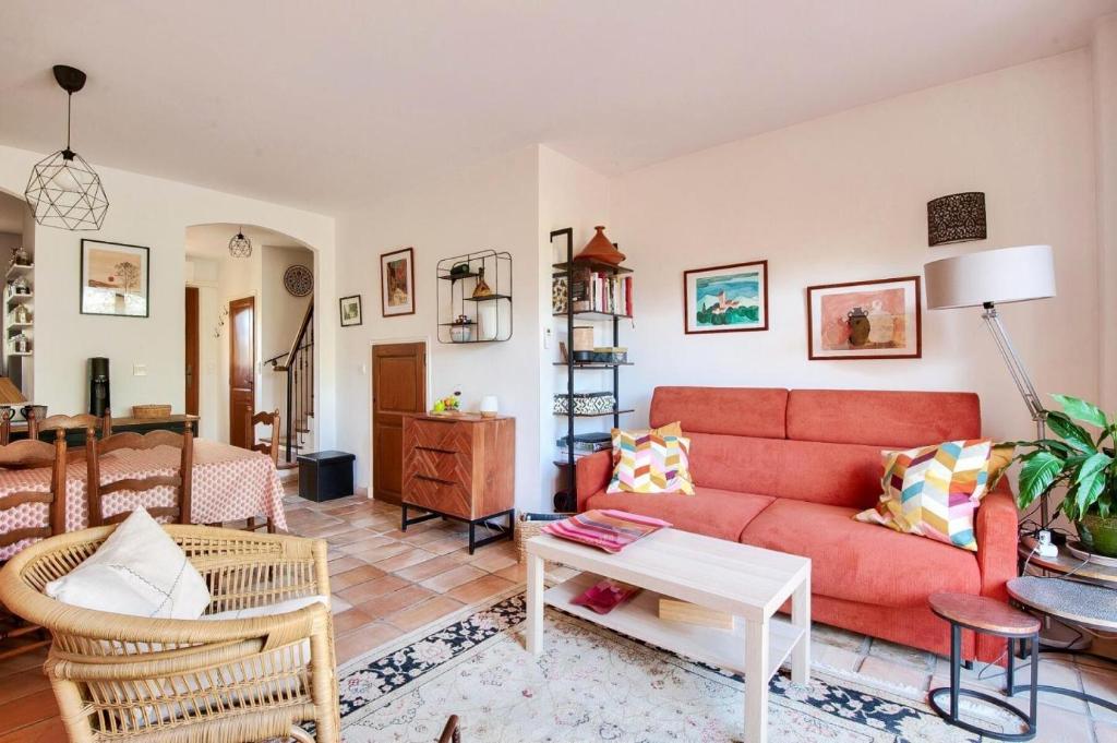 a living room with a red couch and a table at Les Mas et Villas de Pont Royal en Provence - maeva Home - Villa duplex moderne et vintage 3 pièces 6 personnes climatisée - Prestige - super Home MAE-4211 in Mallemort