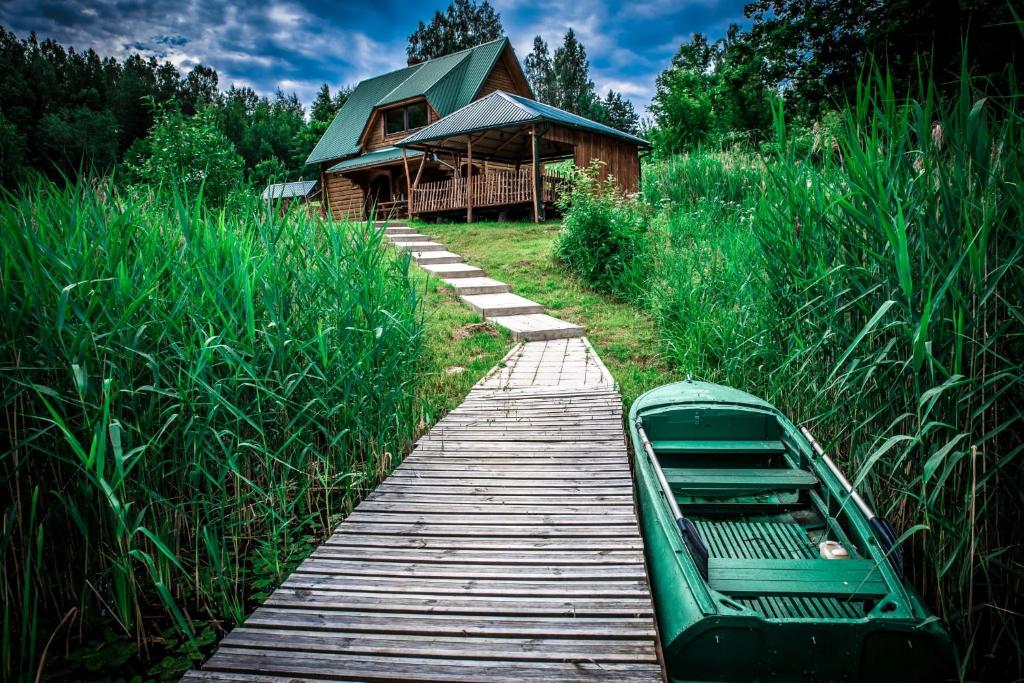 a wooden walkway leading to a house and a wooden cabin at Purvmaļi in Daugavpils