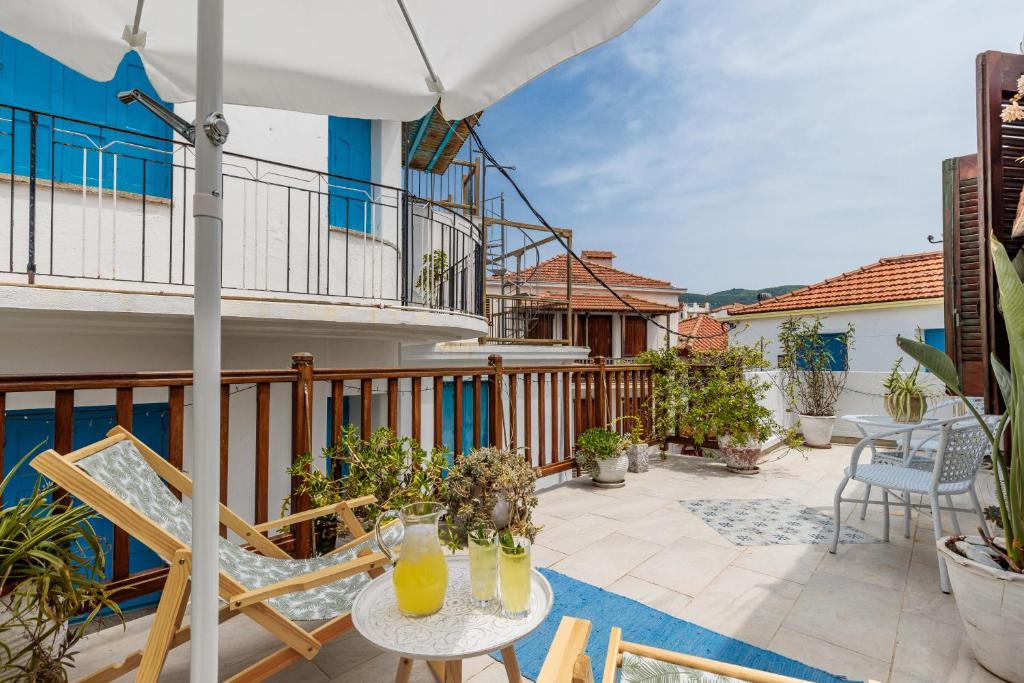 a patio with a table and chairs on a balcony at Amaranthos Village Home in Skopelos Town