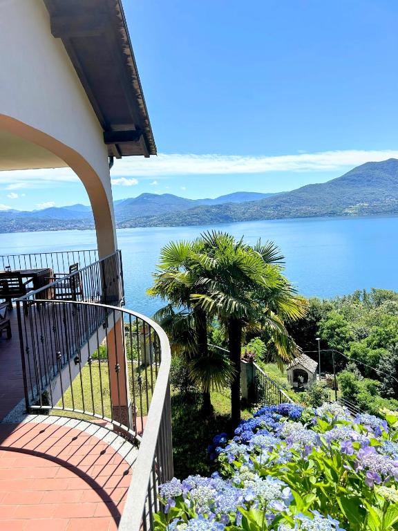 a balcony of a house with a view of the water at Lago Maggiore - Traumbalkon mit Seeblick & Pool und 2 SZ in Oggebbio