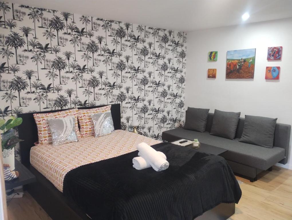 une chambre avec un lit et un canapé dans l'établissement Studio le Trésor d'amour, à Noyers-sur-Cher