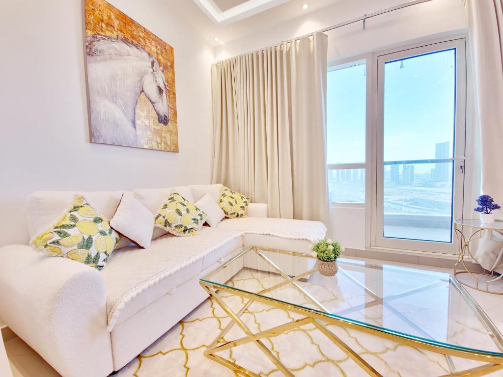 アブダビにあるHarf2102 OS 2BR in Alreem Islandのリビングルーム(白いソファ、ガラスのテーブル付)