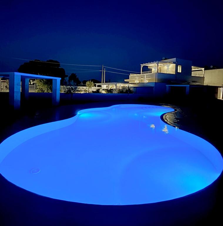 a blue lighted swimming pool at night at Lux apartments in Porto Cesareo