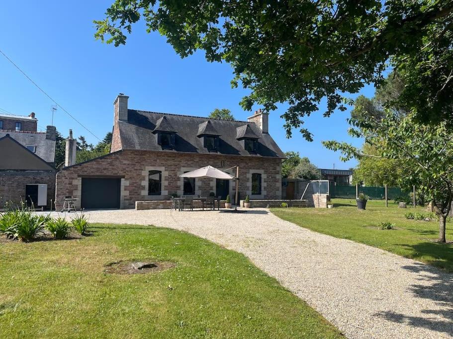 Une vieille maison en briques avec une table de pique-nique devant elle dans l'établissement Ti Ar Familhou classée 3 étoiles, à Paimpol