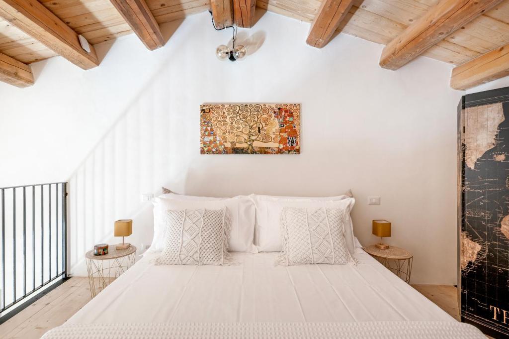 une chambre avec un grand lit avec des oreillers blancs dans l'établissement U'Marranzanu Exclusive Relais, à Noto