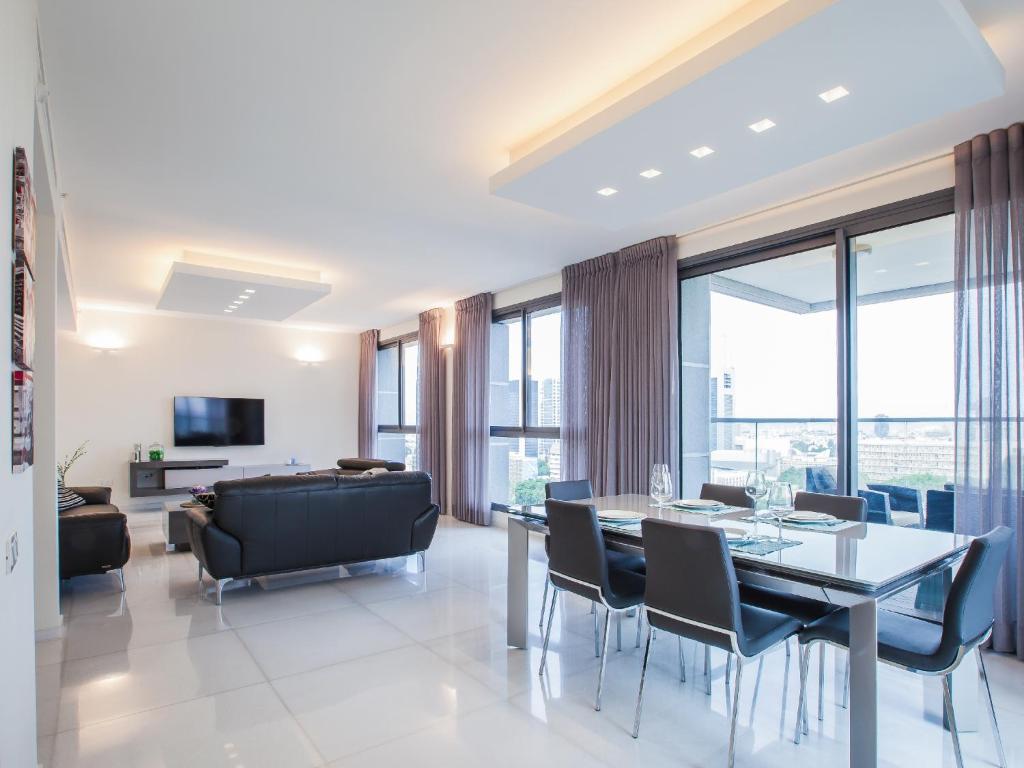 a dining room with a table and chairs and a couch at Tel Aviv Vacation Apartments in Tel Aviv