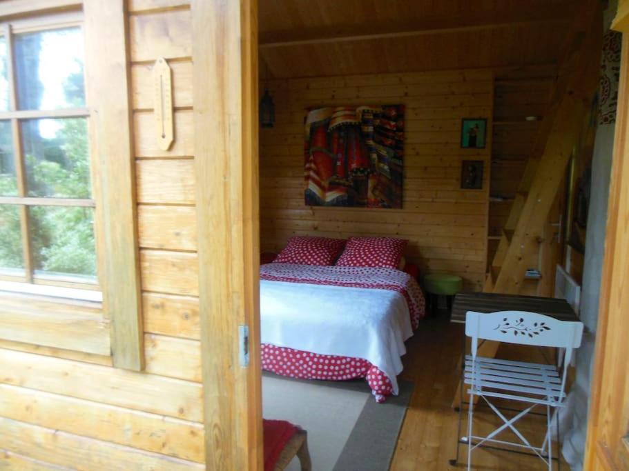 a bedroom with a bed in a wooden cabin at Charmant chalet en bois in Vielle-Saint-Girons