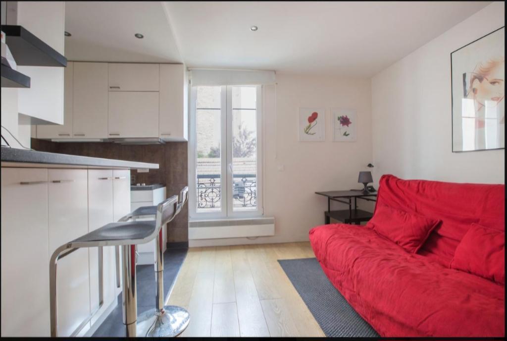 un salon avec un canapé rouge et une cuisine dans l'établissement Magnifique studio Cannes, à Cannes