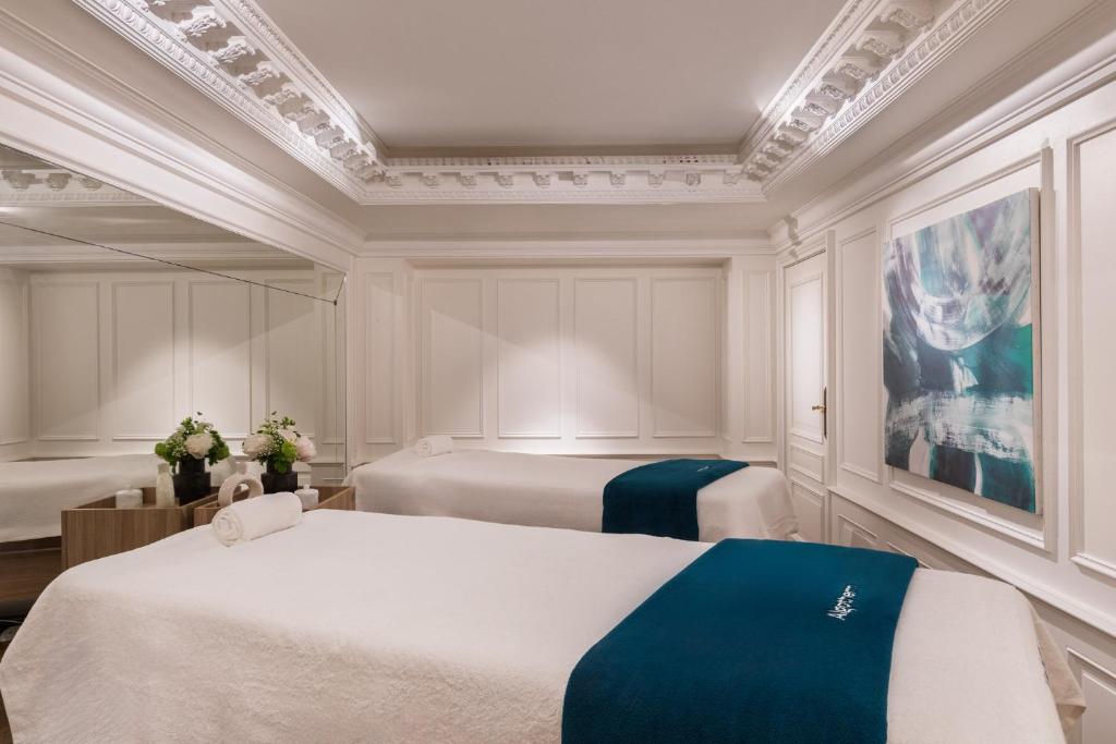 a bedroom with two beds and a painting on the wall at InterContinental Paris Le Grand by IHG in Paris
