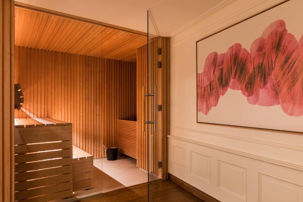 a bathroom with a glass door and a painting on the wall at InterContinental Paris Le Grand by IHG in Paris