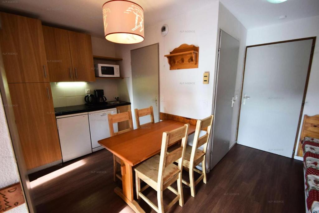 - une cuisine avec une table et des chaises en bois dans la chambre dans l'établissement Résidence Le Cervin - 2 pièces 4 pers- WIFI- Le CERVIN- PLAGNE SOLEIL MAE-7724, à Aime La Plagne