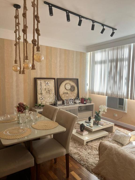 a living room with a table and a dining room at Apt Icaraí Niterói Leonardo Davince in Niterói