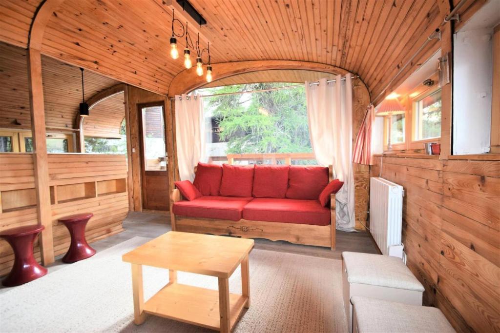 Una sala de estar con un sofá rojo y una mesa. en Chalet Schi Jaacas - Chalet SCHI JAACAS - 8/10 pers - PLAGNE CENTRE MAE-8424, en Aime La Plagne
