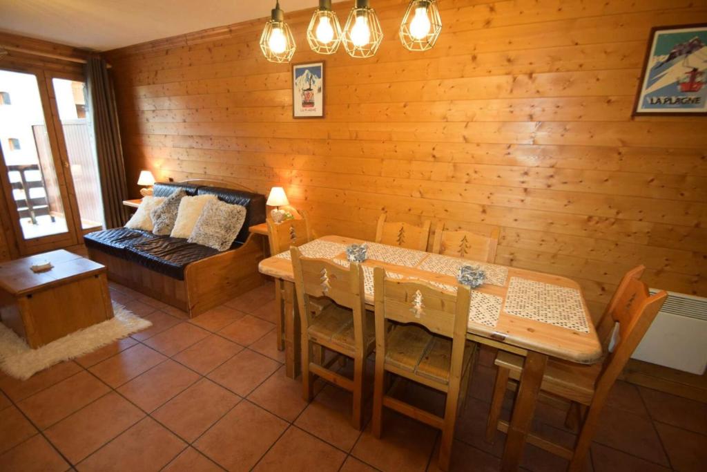une salle à manger avec une table et un canapé dans l'établissement Résidence Lodges Des Alpages - 3 Pièces 6 pers - LES LODGES DES ALPAGES - PLAGNE SOLEIL MAE-4284, à Aime La Plagne