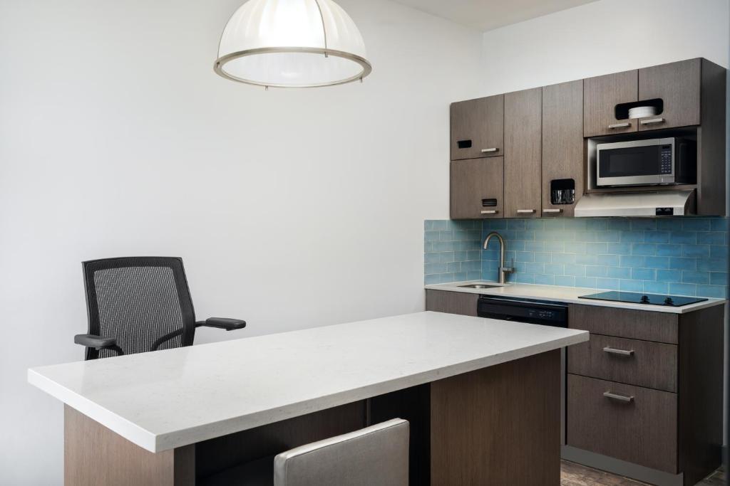 a kitchen with a white counter top and a sink at Hyatt House Naples 5th Avenue in Naples
