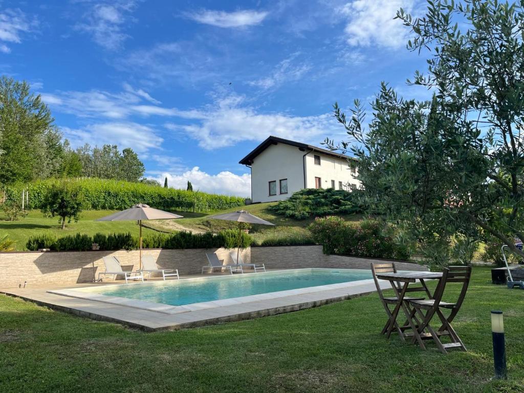 un cortile con piscina e una casa di Vigne dei Mastri a Costigliole dʼAsti