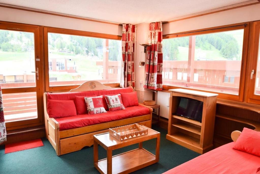 un salon avec un canapé rouge et une télévision dans l'établissement Résidence La Meije - 2 Pièces divisible 6 pers - LA MEIJE - PLAGNE CENTRE MAE-1924, à Aime La Plagne