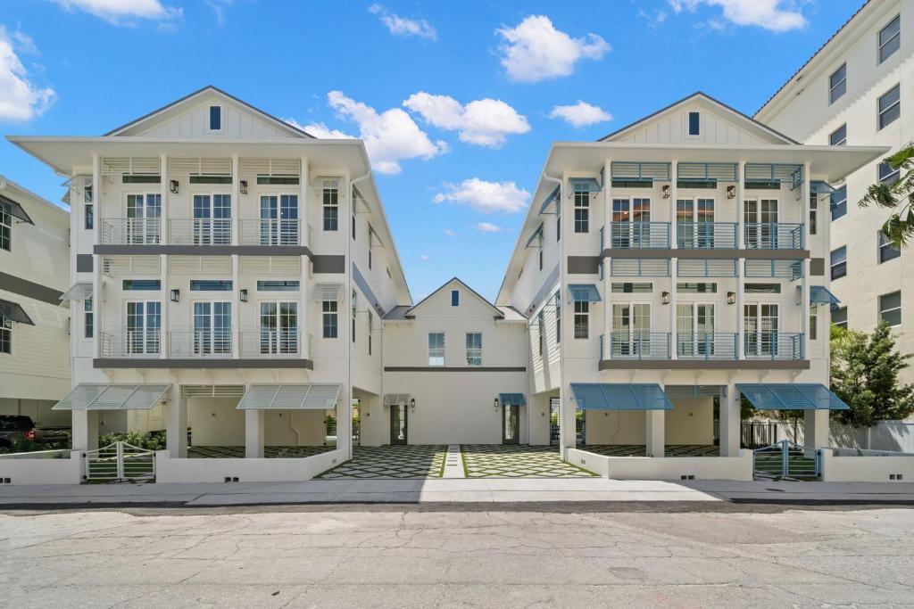 a row of white buildings with a blue sky in the background at The Akoya & Pearl Houses at the Gemma - 2 Homes with Private Pools Just Steps to Clearwater Beach in Clearwater Beach