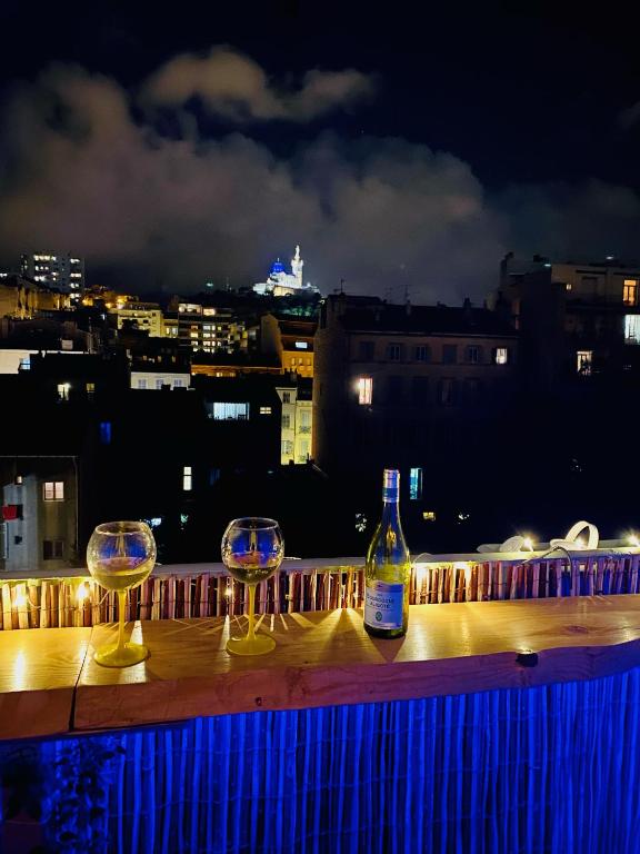 deux verres à vin et une bouteille sur une table le soir dans l'établissement Superbe T2 au coeur de Marseille, à Marseille