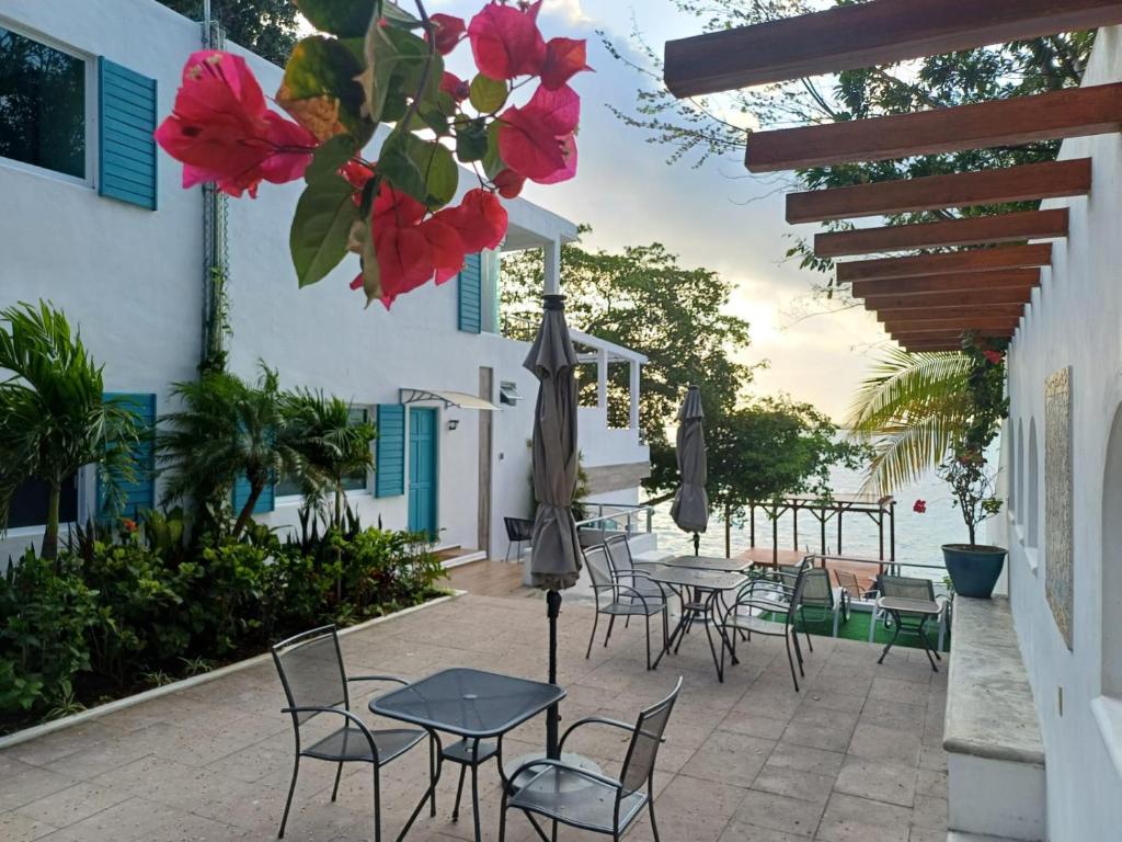 un patio con mesas, sillas y flores en Zensus Laguna, en Bacalar