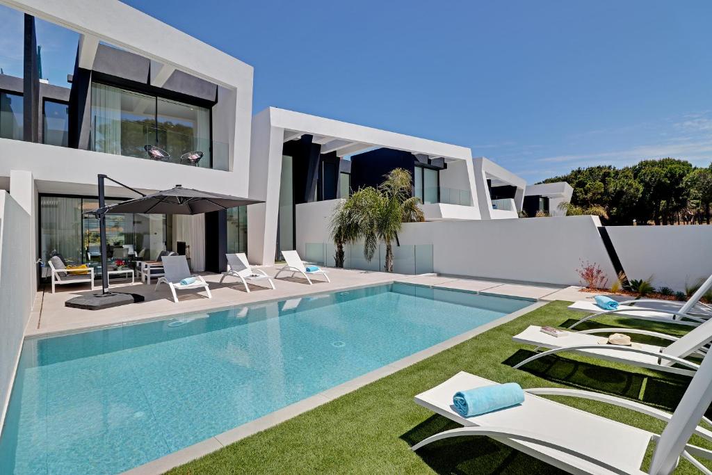 a villa with a swimming pool and a house at One Six Villa in Vilamoura