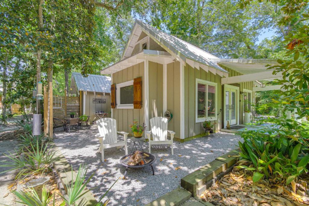 a house with chairs and a fire pit in front of it at Historic Biloxi Bay Cottage with Beautiful View in Ocean Springs