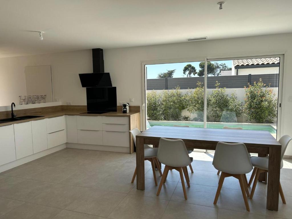a kitchen and dining room with a table and chairs at Villa moderne et confortable in Béziers