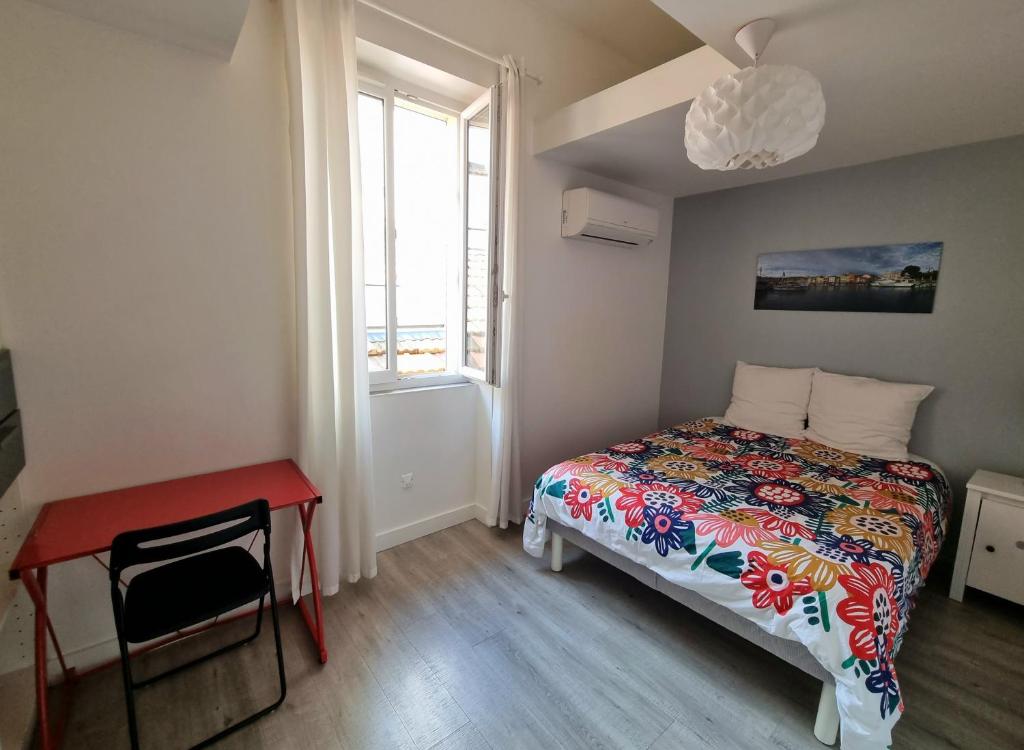 une chambre avec un lit, un bureau et une fenêtre dans l'établissement Les Demeures de Castellane, à Marseille