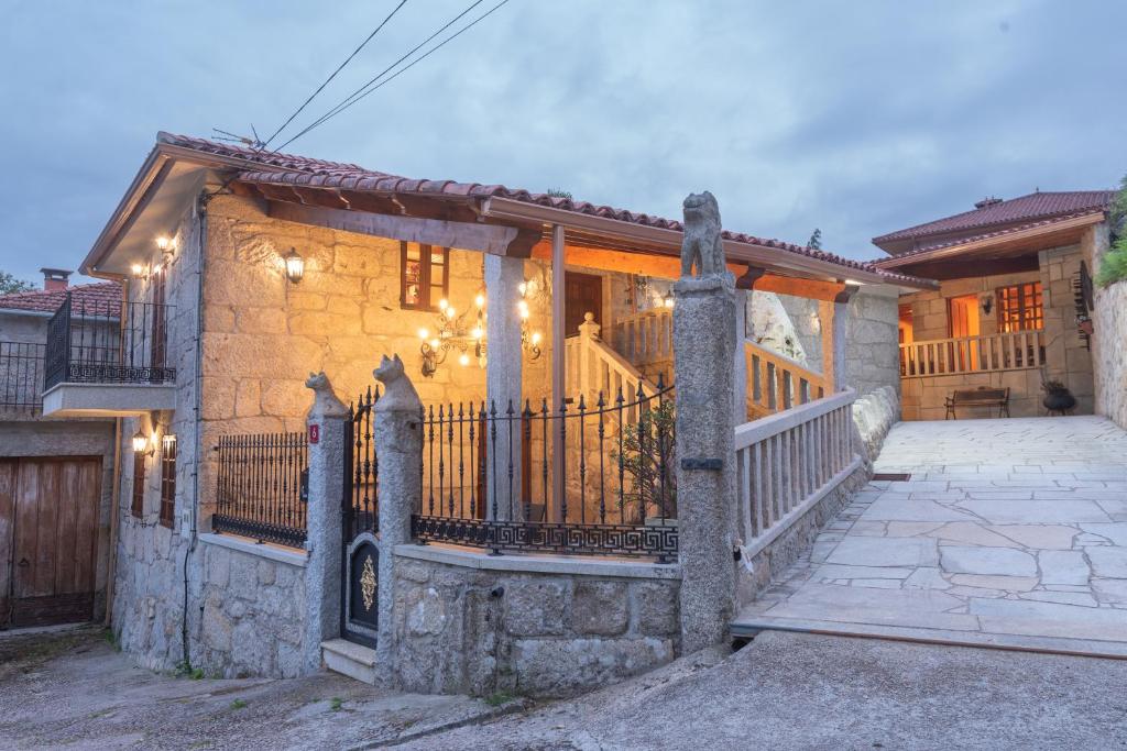 ein Steinhaus mit einem Tor und einem Zaun in der Unterkunft Casa Magariños in Gondomar