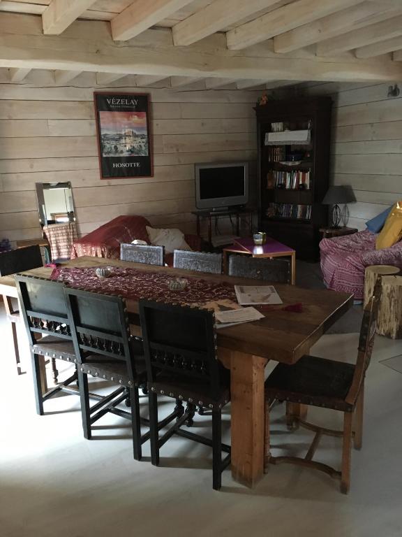 un salon avec une table et des chaises en bois dans l'établissement La Grange, à Saint-Père