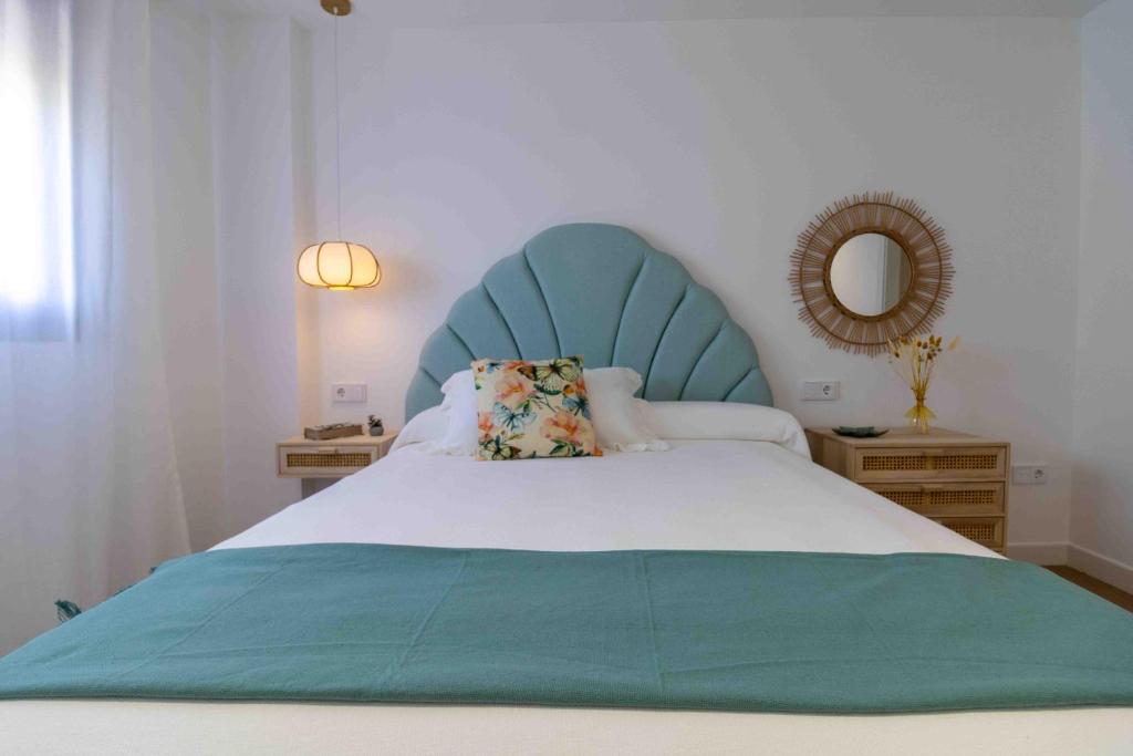 a bed with a blue headboard and a pillow on it at Artes Homes in San José