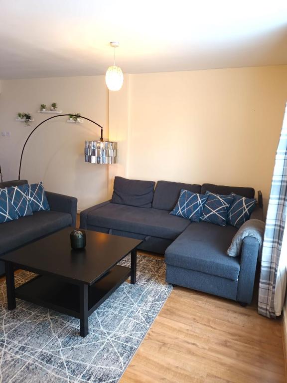 una sala de estar con un sofá y una mesa en Fabulous 2 bed apt 10 mins from City Centre, en Glasgow