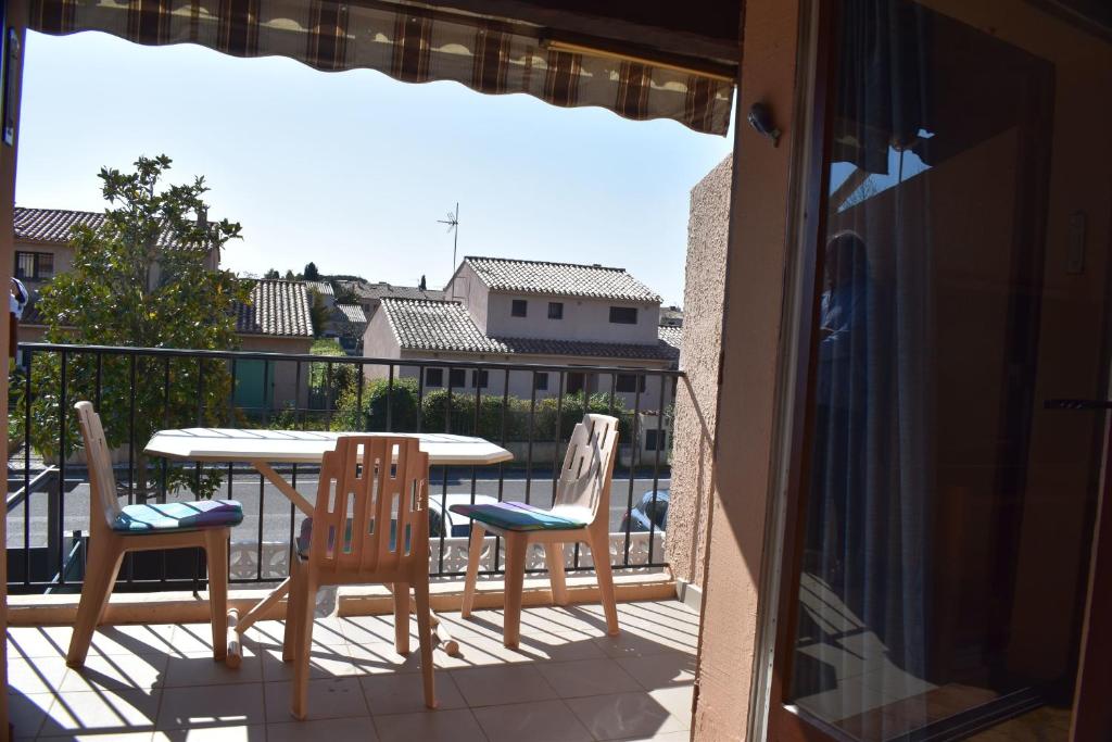 un patio avec une table et des chaises sur un balcon dans l'établissement Cozy 34 m studio near the sea, à La Londe-les-Maures