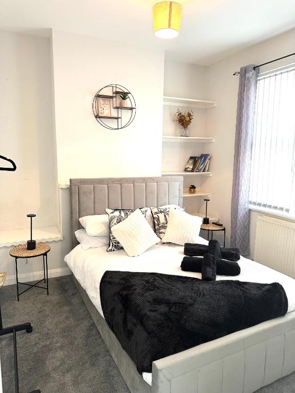 a bedroom with a large bed with black blankets and pillows at Ty Noah- Home In The Heart Of Pembrokeshire in Milford Haven